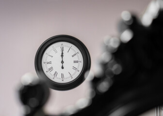 12:00 twelve o'clock time on the wall with selective creative focus.  Big black coloured wall clock.