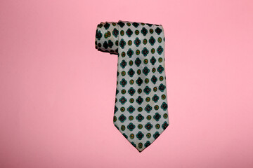 retro old tie on pastel pink background in close-up