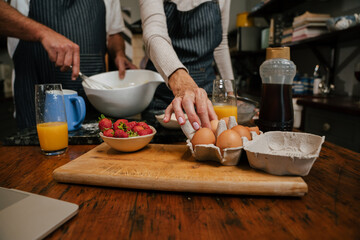 caucasian elderly couple baking in kitchen close up
