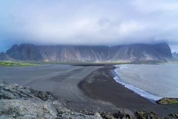 Beautiful black sand beach with Vestrahorn mountain on Stokksnes cape, Iceland in the mist in the background.