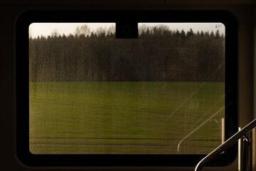 Green landscape with trees as seen from a train window