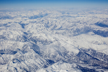 Panoramic view of snowy Alps from above, view from airplane window