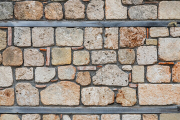 The antique wall is paved with gray stones, top view. stone texture, outdoor stone tiles