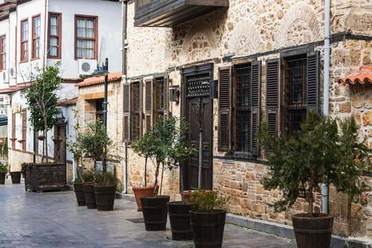 Close-up Of A Wooden Door And Flower Pots In A Brown  Stone Building