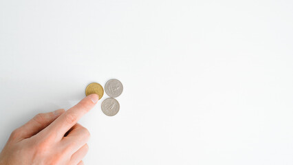 Business concept, financial problems, poverty, poor, crisis. Top view hand counting money on white table, banner with copy space. Close-up of finger touching coins cents