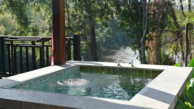 Natural hot spring pool on outside balcony in tropical resort among the nature