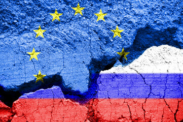 Russian and European flags on cracked ground background. Europe and Russia crisis concept during Ukraine  war