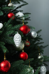 Obraz na płótnie Canvas Beautifully decorated Christmas tree on grey background, closeup