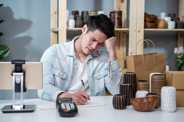 Depressed Asian male feel worried about financial problem in business. 