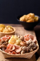 Mixed fresh mushroom (Edible mushroom) in bamboo basket on wooden background prepare for cooking