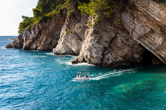 Petrovac, Montenegro, 29. august 2021: Boat at sea with tourists near the clifs in town Petrovac, Montenegro