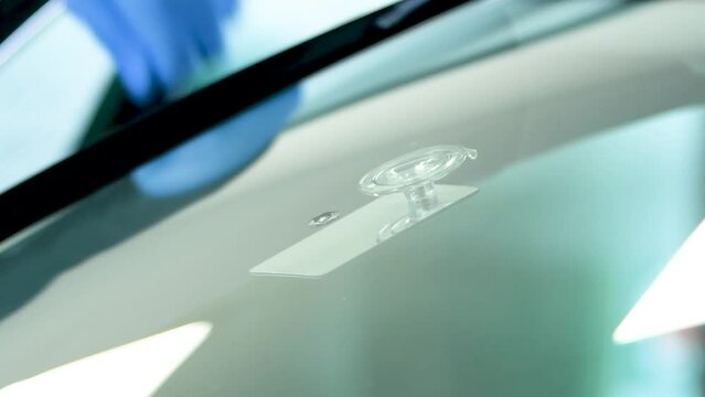 technican placing a mirror below an stone chip before fixing the car glass