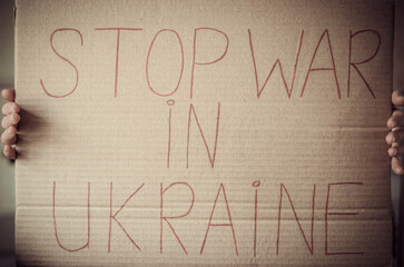 The inscription stop war in Ukraine on cardboard paper in female hands