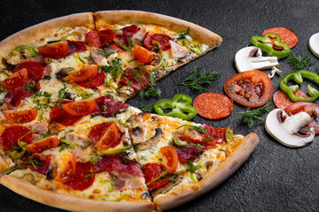 pizza with ingredients on a dark background