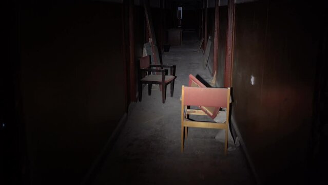 destroyed room of the old building, the beam of the lantern illuminates the old dirty walls and floor. Shooting from the first person. the concept of devastation after hostilities.