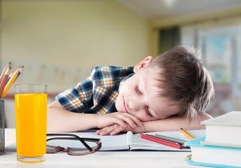 Exhautsed kid teen doing homework alone, sitting at table full of exercise books,