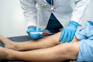 Asian doctor inject Hyaluronic acid platelet rich plasma into the knee of senior woman to walk...