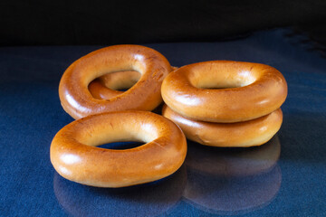 Round bagel on a blue table with reflection