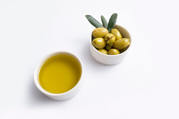 olives and olive oil in bowl on white background
