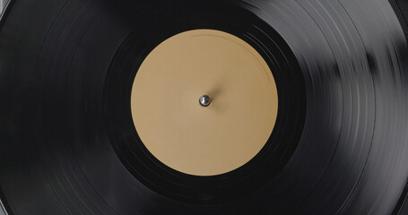 Black vinyl background with a beige screen in the center. A vinyl record on DJ turntable record player close up. Rotating plate and stylus with the needle close-up.