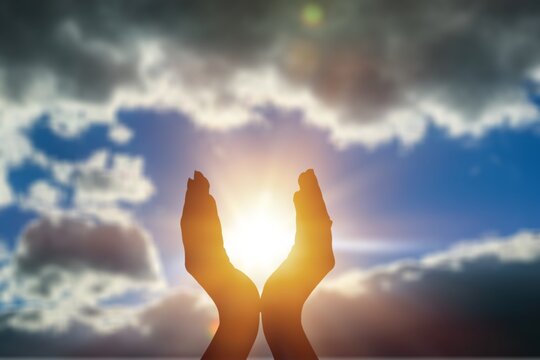 Summer sun concept with silhouette of young woman's hands relaxing, happy meditating