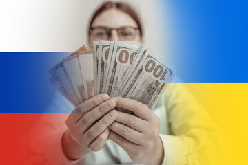 War in Ukraine. Sad business woman covering her face with money against blue and yellow Ukrainian...