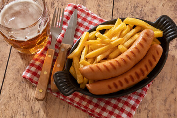 dish of fries with frankfurters and a beer