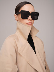 Beautiful young lady in a beige trench coat - 489914168