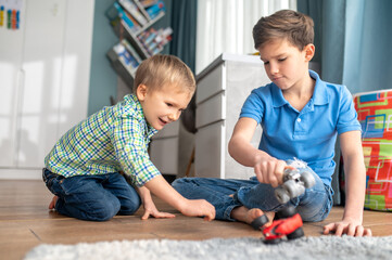 Focused elder brother entertaining his younger sibling