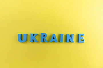 Ukraine name written with Blue letters on a plain Yellow Background