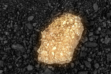 a pebble floor with a shining stone in the middle. glowing yellow stone
