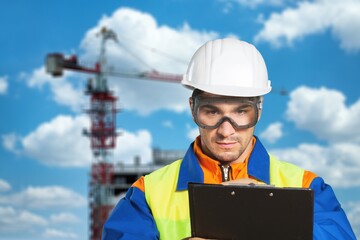 Serious and focused architect or engineer working on construction site, checking list