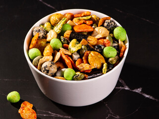 Various Japanese snacks in a wooden bowl close-up. Rice crackers with wasabi and nori, peanuts with sesame seeds, and other snacks. Mix traditional Japanese snack food.