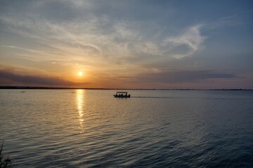 Beautiful landscape with boat in the middle of the lake during sunset