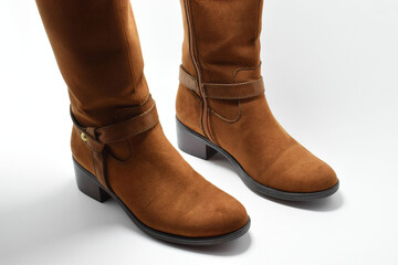 Botas altas para mujer. Botas cafés de piel, calzado elegante sobre un fondo blanco, espacio para texto al lado derecho, vista superior.