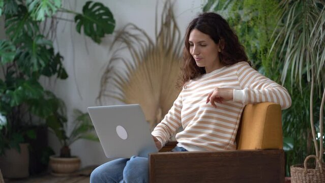 Joyful young woman spend weekend chatting in social media with friends using laptop. Happy millennial female do online dating flirting with man in web. Smiling girl typing message email in internet