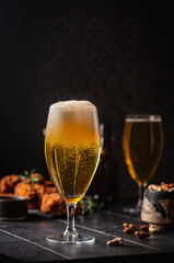 Glass of light beer on dark background. Selective focus