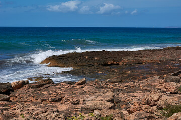 Rocks on the shore hit by the wave