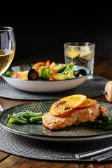 grilled fish with a side dish on a wooden background. Restaurant