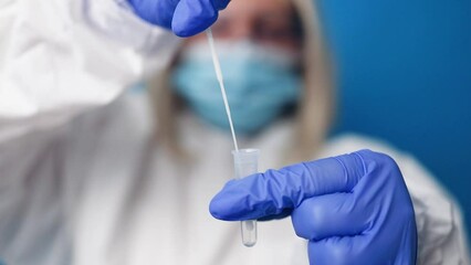 Coronavirus pcr test. Doctor in protective suit medical mask gloves holding Swab saliva sample for diagnostic covid 19 coronavirus virus on blue background