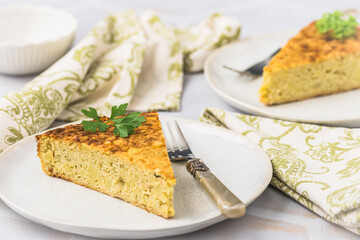 Two pieces of a potato cake, spanish tortilla, frittata, on white background