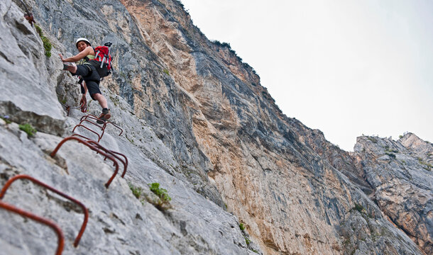 Woman climbing up the Che Guevara Via Ferrata in Italy