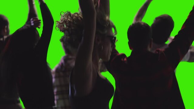 Some teenagers are jumping and dancing with their hands raised facing the opposite direction greenscreen
