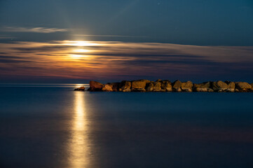 Fototapeta premium alba di luna sul mare adriatico con scogliera