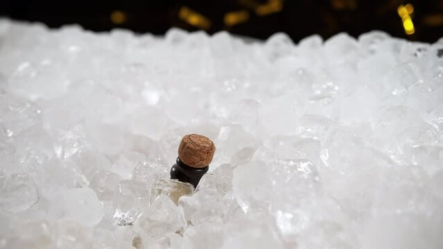 Champagne Bottle Popping out from under the Ice Cubes and Uncorking in Slow Motion