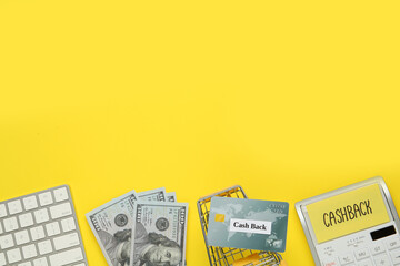 Calculator, keyboard, credit card, shopping cart and dollar banknotes on yellow background, flat lay with space for text. Cashback concept