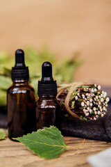Cosmetics for spa treatments and baths on a wooden table with a birch broom. Essential oils.