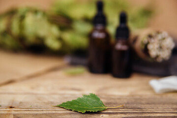 Cosmetics for spa treatments and baths on a wooden table with a birch broom.Blurred background.