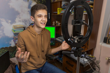 teenager is engaged in blogging sitting at a table in his room