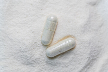 collagen in tablets and powder on wooden white background.